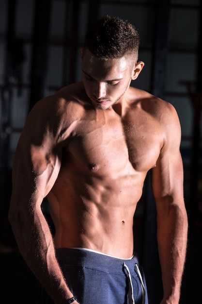 Free photo good-looking athletic young man in gym