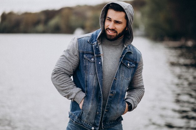 Good looking bearded man by the river in park