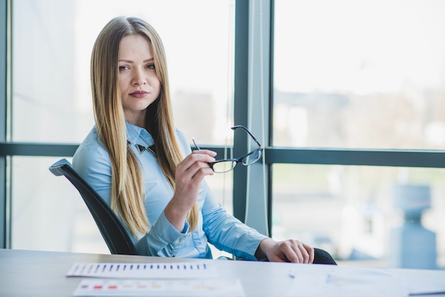 Free photo good looking businesswoman holding glasses