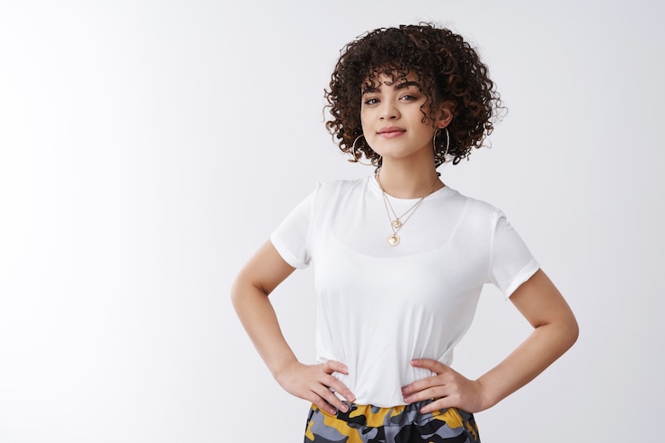Free Photo good-looking curly-haired mixed-race girl hipster stylish outfit hold hands waist confident enthusiastic smiling satisfied self-assured, woman giving lecture feminism women power, white background