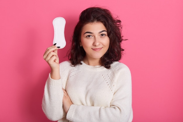 Good looking feminine girl holds clean sanitary napkin
