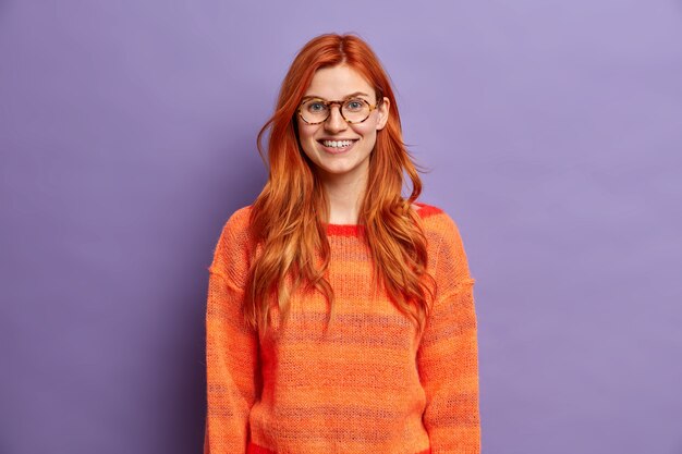 good looking ginger woman smiles happily dressed in casual jumper and.
