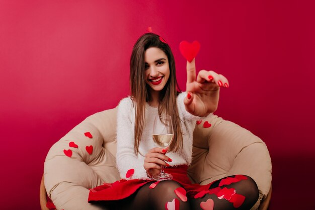 Good-looking girl having fun in valentine's day and playing with confetti