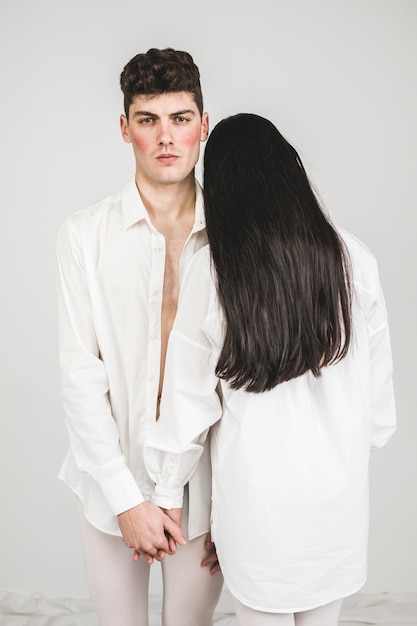 good looking models in white holding hands