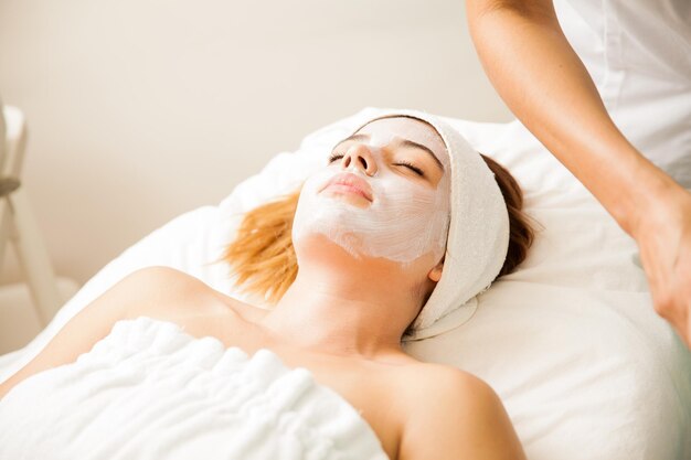 Good looking young woman in the middle of a cellular rejuvenation face treatment at a beauty spa