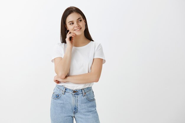 Good-looking young woman posing against white wall