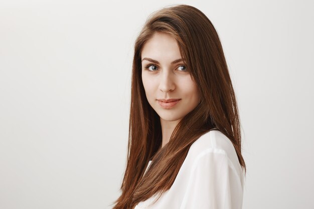 Good-looking young woman smiling at front confident