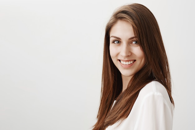 Good-looking young woman smiling at front confident