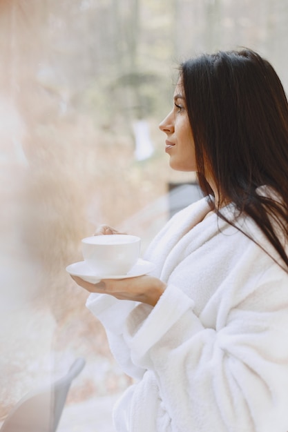 Free Photo good morning. woman drinks coffe. lady by the window.