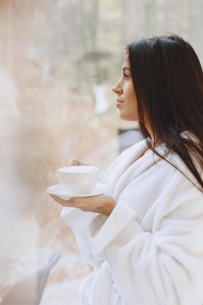 Good morning. Woman drinks coffe. Lady by the window.