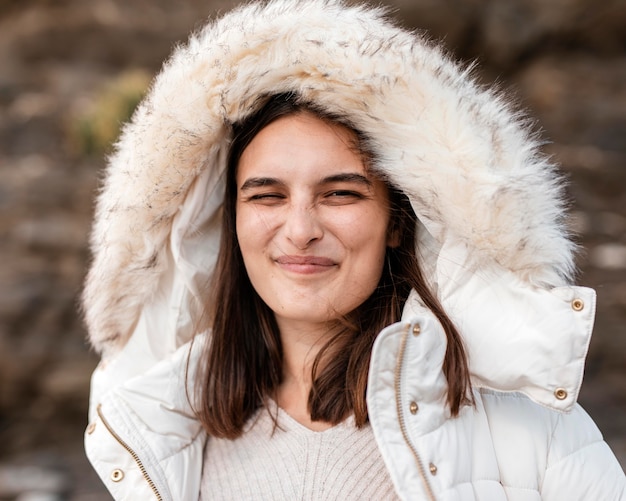 Goofy woman at the beach posing with winter jacket