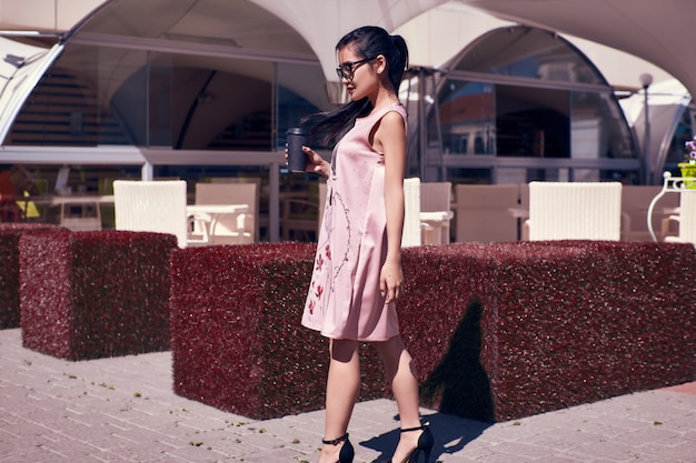 Gorgeous asian woman in fashion dress on terrace of the restaurant