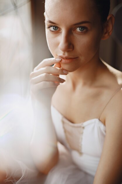 Gorgeous ballet dancer. Ballerina in pointe. Girl by the window.