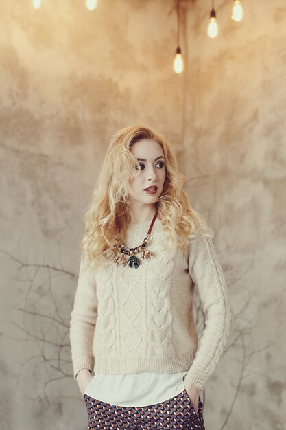 Foto gratuita donna bionda splendida in maglione beige