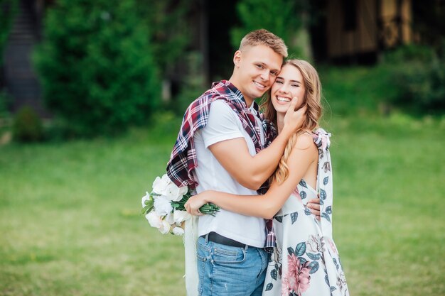 Gorgeous blonde girl hugging and smiling with her attractive man one sunny day