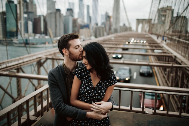 Gorgeous couple of american man with beard and tender eastern woman hug each other