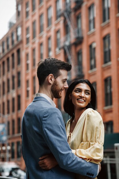 Gorgeous couple of American man with beard and tender Eastern woman hug each other