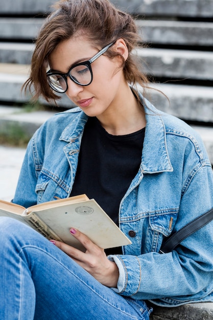 Gorgeous female reading book sitting on stairs