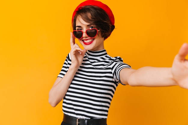 Gorgeous french woman with short hair taking selfie