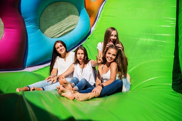 Gorgeous girls having fun on a slide on a sunny day