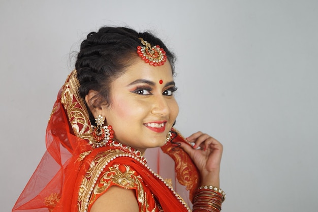 Free photo gorgeous indian bride with heavy makeup wearing traditional indian bridal attire and posing