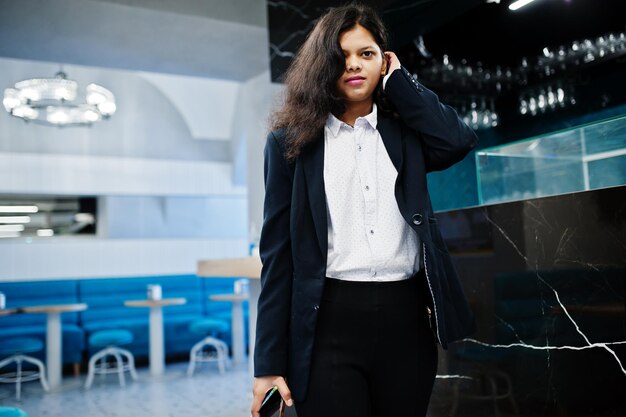 Gorgeous indian woman wear formal posing at cafe near bar counter