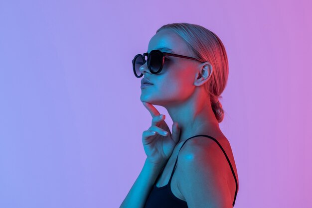 Gorgeous lady in sunglasses on neon