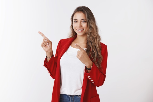 옆으로 손가락을 가리키는 빨간색 트렌디한 재킷을 입은 멋지고 성공적인 현대 여성 사업가