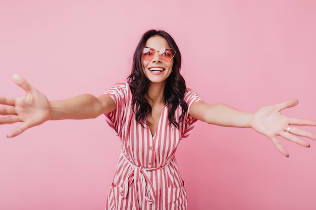 Gorgeous young woman in pink summer attire expressing good emotions. Photo of relaxed brunette lady isolated.