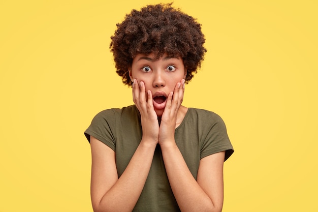 Free photo gosh, something awful happening. impressed amazed woman with afro hair drops jaw