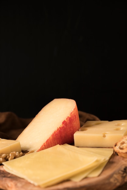 Foto gratuita formaggio gouda con fette di formaggio su sottobicchiere in legno