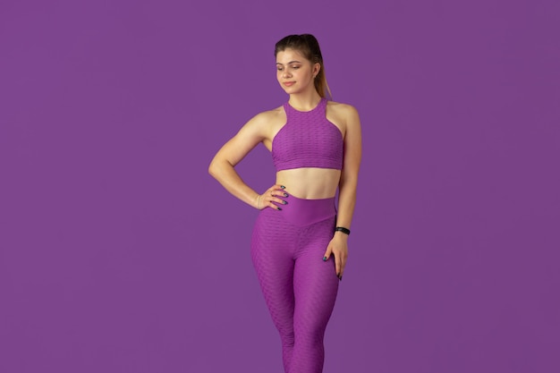 Grace. Beautiful young female athlete practicing , monochrome purple portrait. Sportive caucasian fit model posing confident. Body building, healthy lifestyle, beauty and action concept.