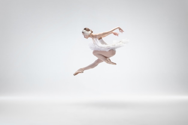 Изящные классические танцы балерины на белом фоне.