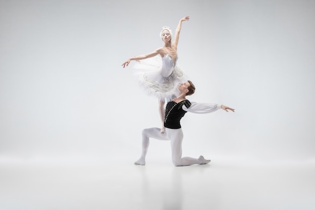 Graceful classic ballet dancers dancing  Couple in tender white clothes like a white swan characters. The grace, artist, movement, action and motion concept.