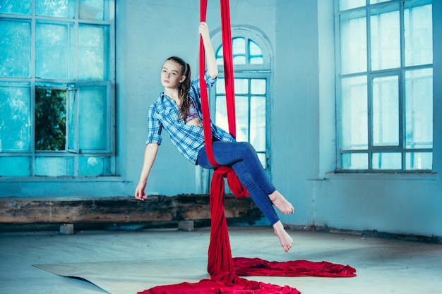 Graceful gymnast performing aerial exercise at loft