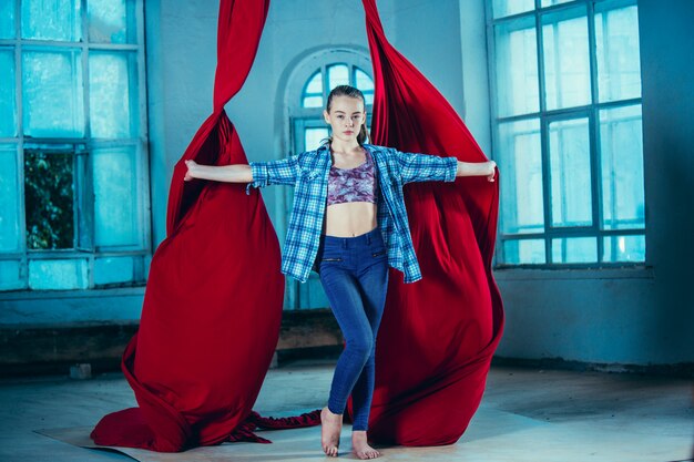 Graceful gymnast resting after performing aerial exercise at loft