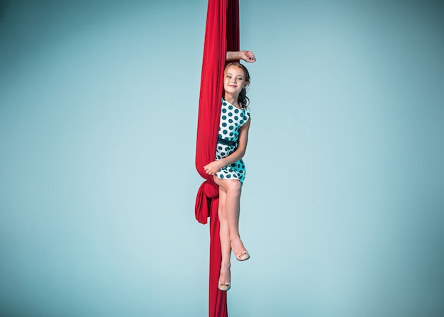 Free photo graceful gymnast sitting with red fabrics