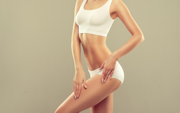 Graceful and slim body dressed in a white sport underwear elegant gesture and healthy perfect figure