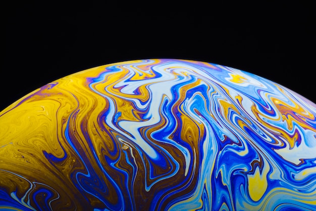 Gradient colorful soap bubble on black background