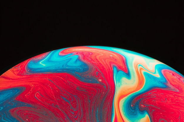 gradient multicolored rippled soap bubble on black background