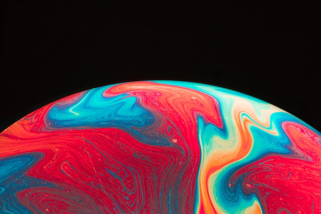 Gradient multicolored rippled soap bubble on black background