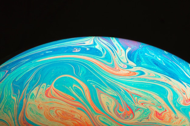 Gradient rippled colorful abstract soap bubble on black background