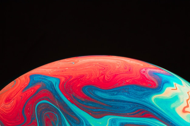 Free photo gradient rippled multicolored soap bubble on black background