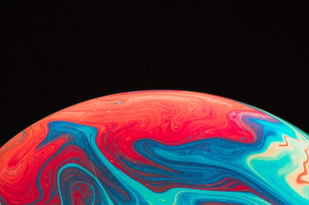 Gradient rippled multicolored soap bubble on black background