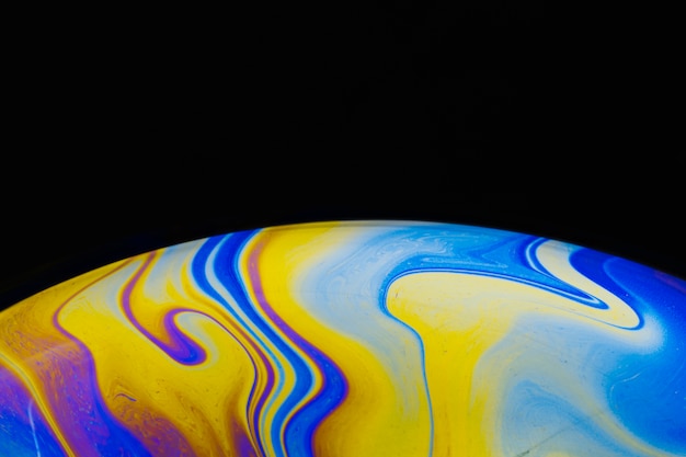 Gradient smooth colorful soap bubble on black background