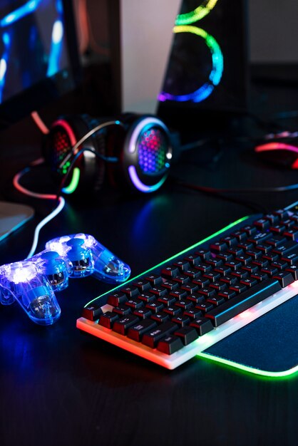 Gradient view of illuminated neon gaming desk setup with keyboard