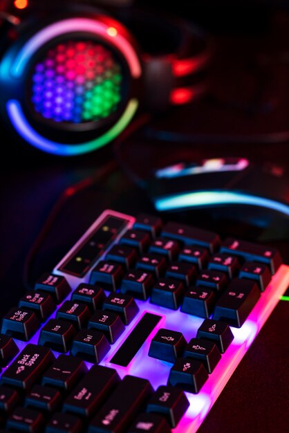 Gradient view of illuminated neon gaming desk setup with keyboard