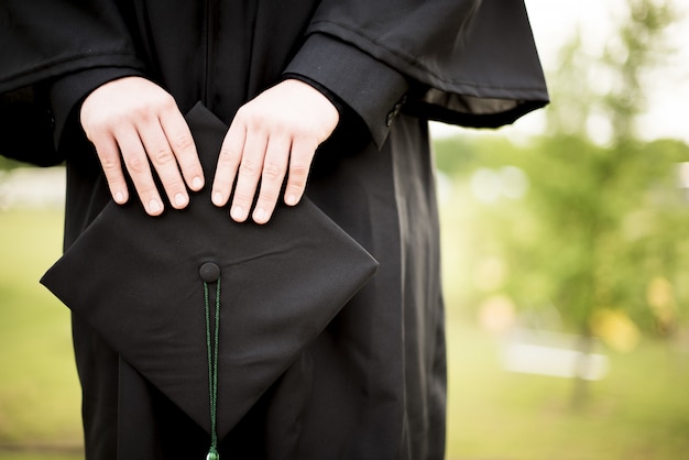 Graduate holding a hat