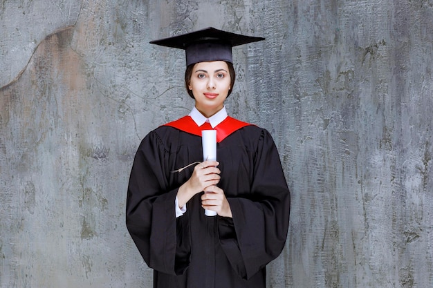 Закончила молодая женщина в платье с университетским дипломом. Фото высокого качества