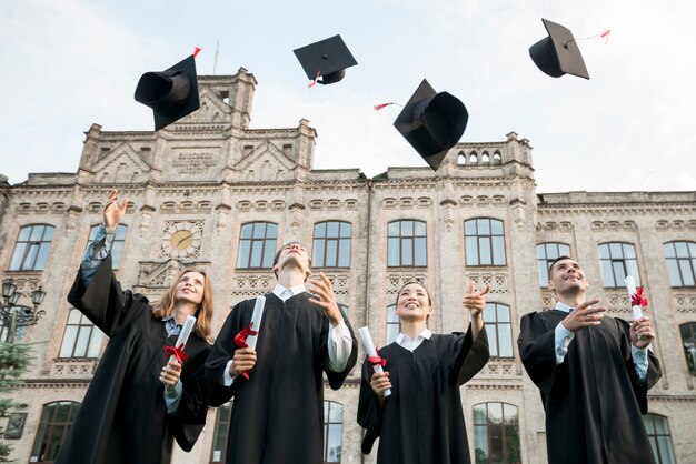 Graduation concept with student throwing hats in air